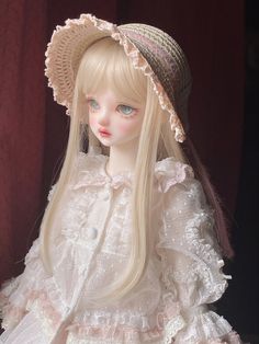 a doll with long blonde hair wearing a hat