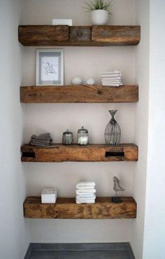 bathroom shelves made out of wood with pictures and towels on the ledges above them