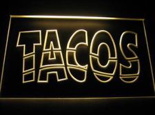 a neon sign that says taco's in white letters on a black background