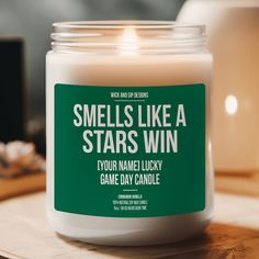 a candle that reads smells like a stars win your name lucky game day candle on a table