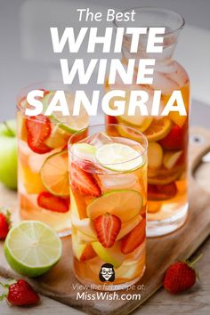 the best white wine sangria with strawberries and limes in glasses on a cutting board