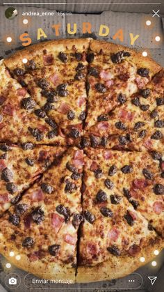 a pizza with several different toppings on it sitting on a wooden table in front of a sign that says saturday