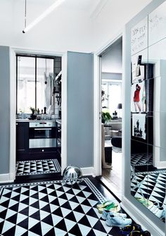 a black and white checkered floor in a room with two mirrors on the wall