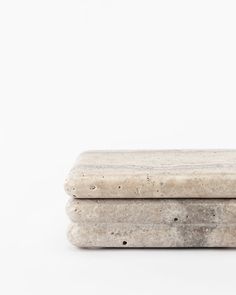 two pieces of stone sitting on top of each other in front of a white background