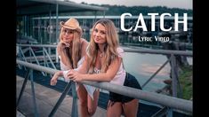 two beautiful young women standing next to each other on a bridge over looking the water