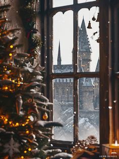 a christmas tree in front of a window with lights on it and a view of the castle