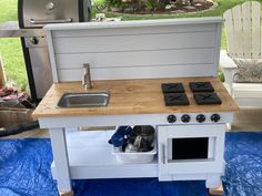 an outdoor play kitchen with stove and sink