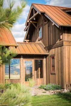 a large wooden house sitting on top of a lush green field