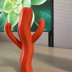 an orange cactus sitting in front of a television