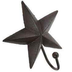 a black metal star hook on a white wall