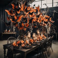 a dining table set with candles and orange flowers