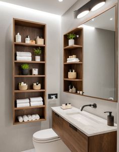 a white toilet sitting under a bathroom mirror next to a wooden shelf filled with towels