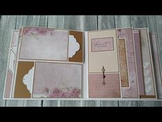 an open book with pink and brown paper on top of wooden table next to scissors