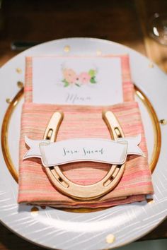 a place setting with napkins and gold rings