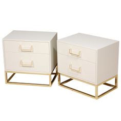 two white nightstands with gold handles on each side and one has a small drawer