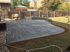 a backyard with a large stone patio in the middle