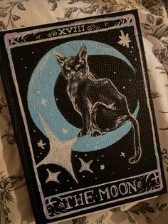 a black cat sitting on top of a blue moon