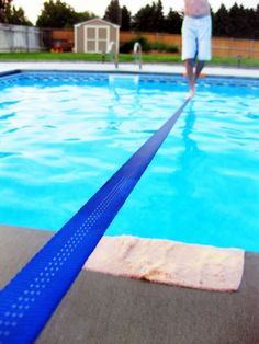 a man standing in front of a swimming pool with a towel on it's edge