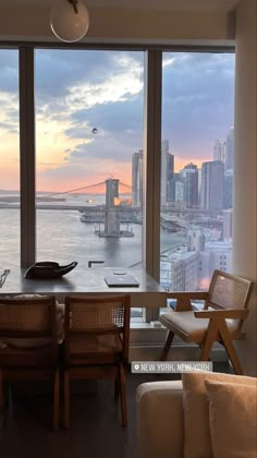 a living room filled with furniture next to a large window covered in windows overlooking the water