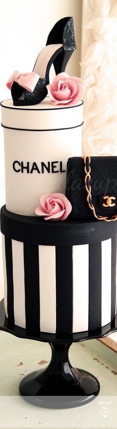 there is a chanel cake with high heels on top and pink roses in the middle