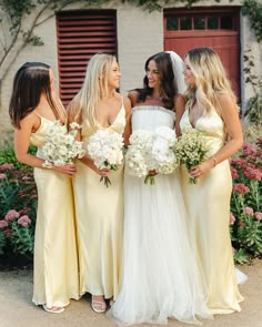 the bridesmaids are all dressed in yellow dresses and holding their bouquets together