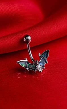 a red shirt with a silver nose ring on it's side and a green stone in the middle