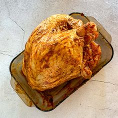 a roasted turkey on a baking pan with gravy