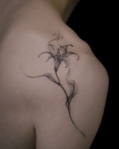 a woman's shoulder with a flower tattoo on it