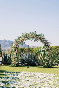 an outdoor ceremony setup with flowers and greenery