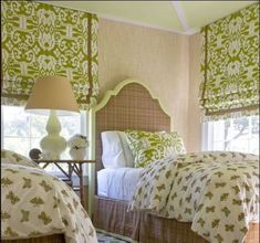 two beds in a bedroom with green and white decor