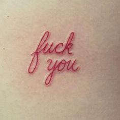 the word fluck you written in red ink on a woman's back stomach