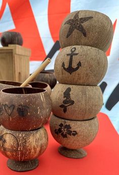 a stack of wooden bowls sitting on top of a red table next to a flag