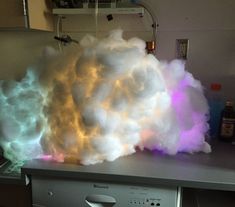 LED Cloud Light: This bright and versatile cloud light can be large or small, color changing or white, and hung from the ceiling or stand alone! Made mainly from paper lanterns and cotton batting, the cloud is easy to assemble and lightweight. Lights are small and b… Cloud Lamp Diy, Diy Cloud Light, Thunder And Lighting, Cloud Ceiling, White Paper Lanterns, Library Crafts, Cloud Night Light, Cloud Lamp