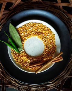 a plate with some food on it and two sticks next to it, sitting on a wicker place mat