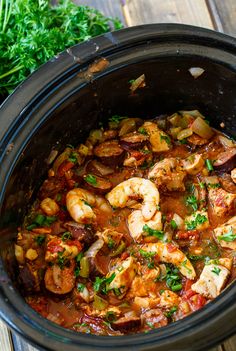 a crock pot filled with shrimp and vegetables