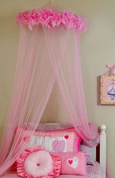 a pink canopy bed in a girls bedroom