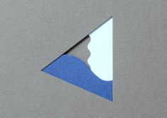 the corner of a piece of paper that has been cut into two triangles with blue and white shapes