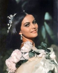 an old photo of a woman in a white dress with flowers on her head and shoulders