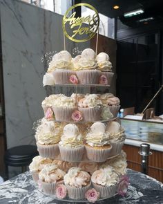 a three tiered cake with cupcakes on top