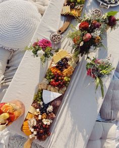 a table topped with lots of food on top of a white cloth covered tablecloth