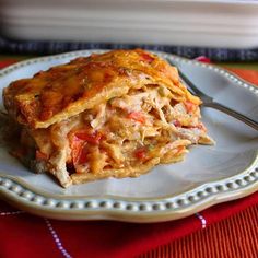 a white plate topped with lasagna covered in chicken