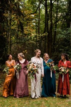 a group of women standing next to each other in front of trees with flowers on them