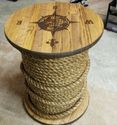 a spool of rope wrapped around a wooden table with an anchor on it's side