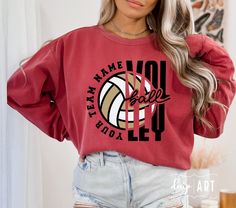 a woman with grey hair wearing a red sweatshirt and shorts that says team name volleyball