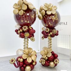 two red and gold vases with flowers on them are standing next to each other