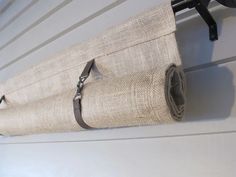 a roll of burlock hanging on the side of a house with a metal hook