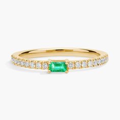 Harmoniously pieced together, this ring features a verdantly-hued baguette-cut emerald center stone on a 14k yellow gold band sparkling with pave-set diamonds for a timeless design. Due to this ring's delicate nature, we do not recommend for daily wear and are unable to resize or repair. Classic Green Diamond Stackable Ring, Classic Green Stackable Diamond Ring, Green Emerald Cut Rings With Half Eternity, Green Baguette Cut Stackable Rings, Stackable Emerald Cut Green Diamond Ring, Green Emerald Baguette Cut Diamond Ring, Stackable Green Emerald-cut Diamond Ring, Green Emerald-cut Stackable Diamond Ring, Emerald Ring In 14k Yellow Gold With Baguette Diamonds