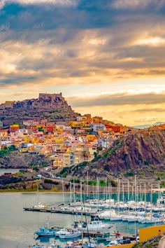 boats are docked in the water near a city on a hill side with a mountain in the background