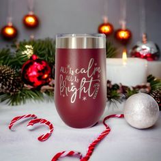 a wine glass sitting on top of a table next to some christmas decorations and candles