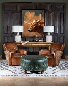 a living room with two leather chairs and a cow painting on the wall